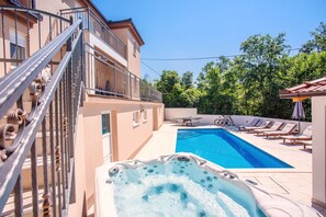 A swimming pool with lounge chairs, a hot tub, and a staircase leading to a balcony. - Last minute! Luxury villa with heated pool and giant jacuzzi! (Runovici)