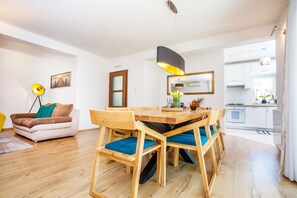 A modern living room with a wooden dining table, blue cushioned chairs, a sofa, and a floor lamp. - Last minute! Luxury villa with heated pool and giant jacuzzi! (Runovici)