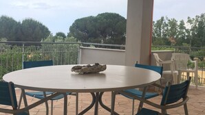 A round outdoor table with blue chairs, a white tablecloth, and a decorative bowl. - apartment on the sea (Badolato Marina)