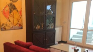 A living room with a red sofa, a glass coffee table, and a dark cabinet. - apartment on the sea (Badolato Marina)