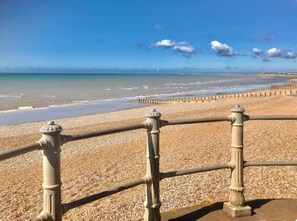 A pebble beach with a metal railing and a clear view of the ocean. - Lovely beachfront Apartment with private courtyard (Saint Leonards-on-sea)