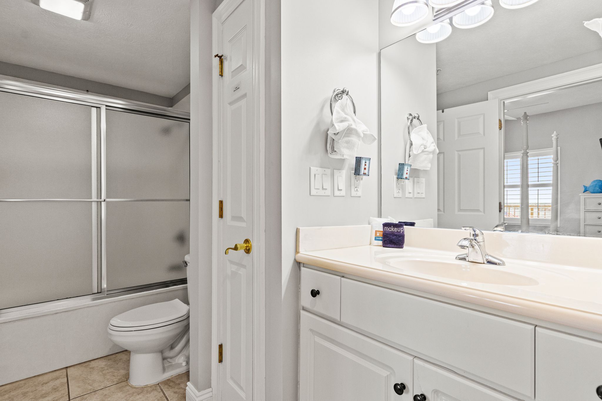A bathroom with a toilet, a sink, and a shower area.