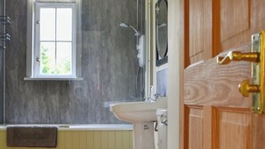 A bathroom with a toilet, sink, and window.