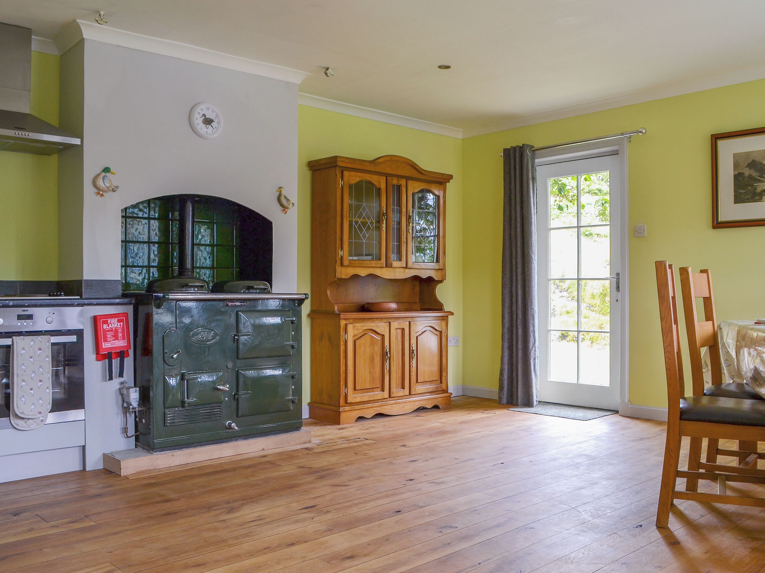 A kitchen with a stove, oven, and wooden cabinet.