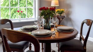 A dining table set with plates, glasses, and a vase of flowers. - 2 bedroom accommodation in York (York)
