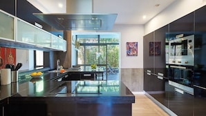 A modern kitchen with a central island, stainless steel appliances, and a view to the outdoors. - Central Holiday Home Pool by Portugal Portfolio (Cascais)