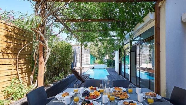 An outdoor dining area with a pool in the background. - Central Holiday Home Pool by Portugal Portfolio (Cascais)