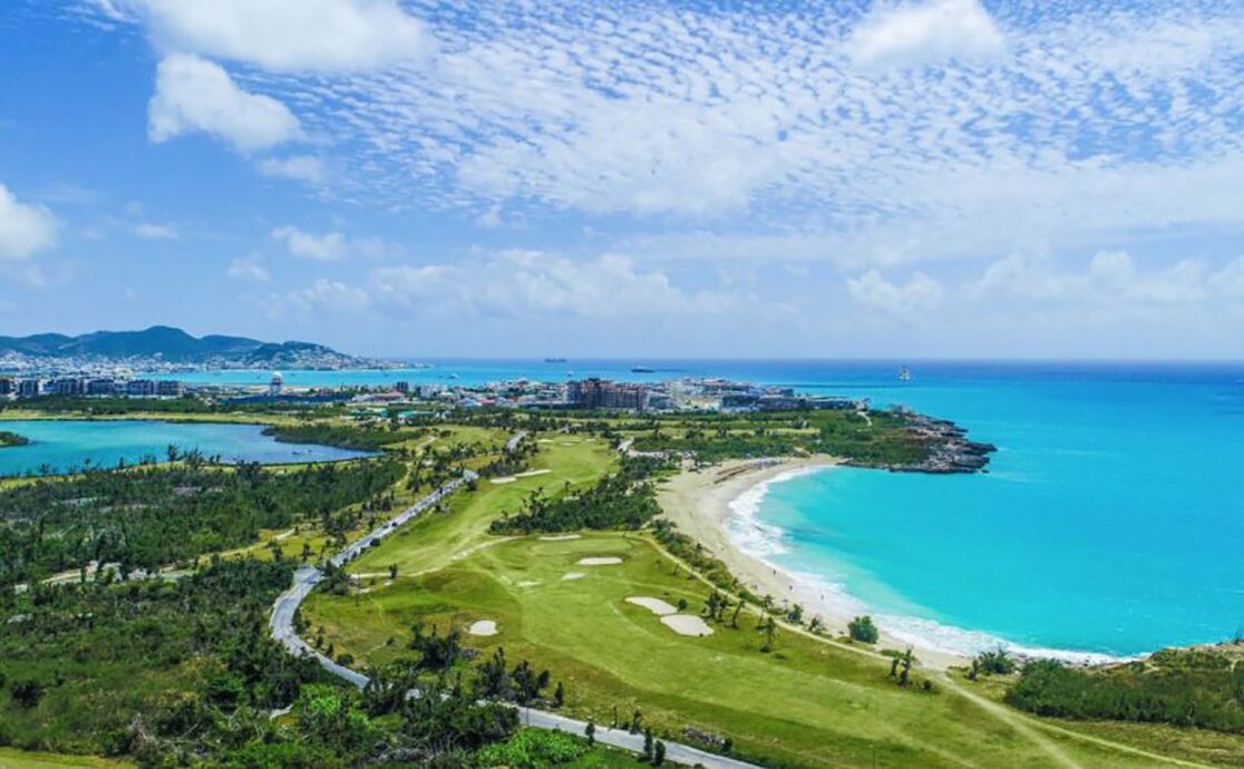 Un resort costero con campo de golf, playa y vistas al océano.