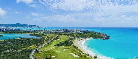 Un resort costero con campo de golf, playa y vistas al océano.