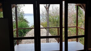 Una habitación con un gran ventanal con vistas a un lago y árboles.