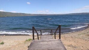 Un sendero de madera que conduce a una playa con un bote en el agua.