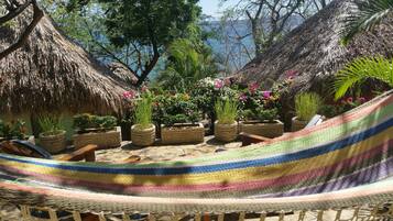 Relax in a serene tropical garden setting, surrounded by lush greenery and a tranquil body of water.