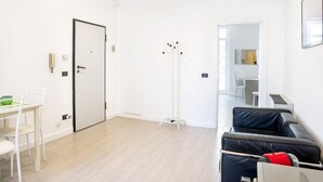 En moderne stue med spiseplads, knagerække og sofa.