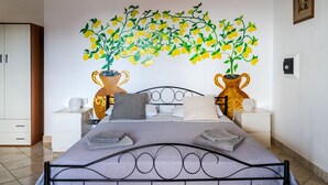 A bedroom with a bed, two nightstands, a wall-mounted lamp, and a decorative wall art of a tree with yellow flowers. - Private Villa with swimming pool for up to 28 guests (Taormina)