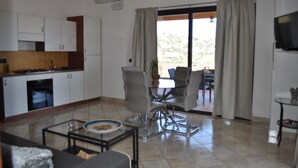 A modern kitchen with white cabinets, a dining area with a glass table, and a TV mounted on the wall. - Private Villa with swimming pool for up to 28 guests (Taormina)