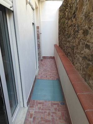 Leading to an entrance, this corridor features a tiled floor and a small mat at the door.