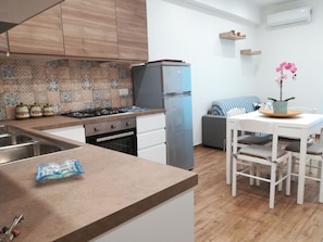 Enjoy cooking in the kitchen with a central island, gas stove, and refrigerator, complemented by a dining area and cozy seating space.