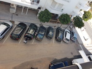 Un parking avec plusieurs voitures et une personne qui marche.