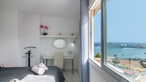 A hotel room with a bed, a desk, a chair, a round mirror, and a view of the sea. - La Estrella 1A020 con vistas panorámicas al mar (Los Cristianos)