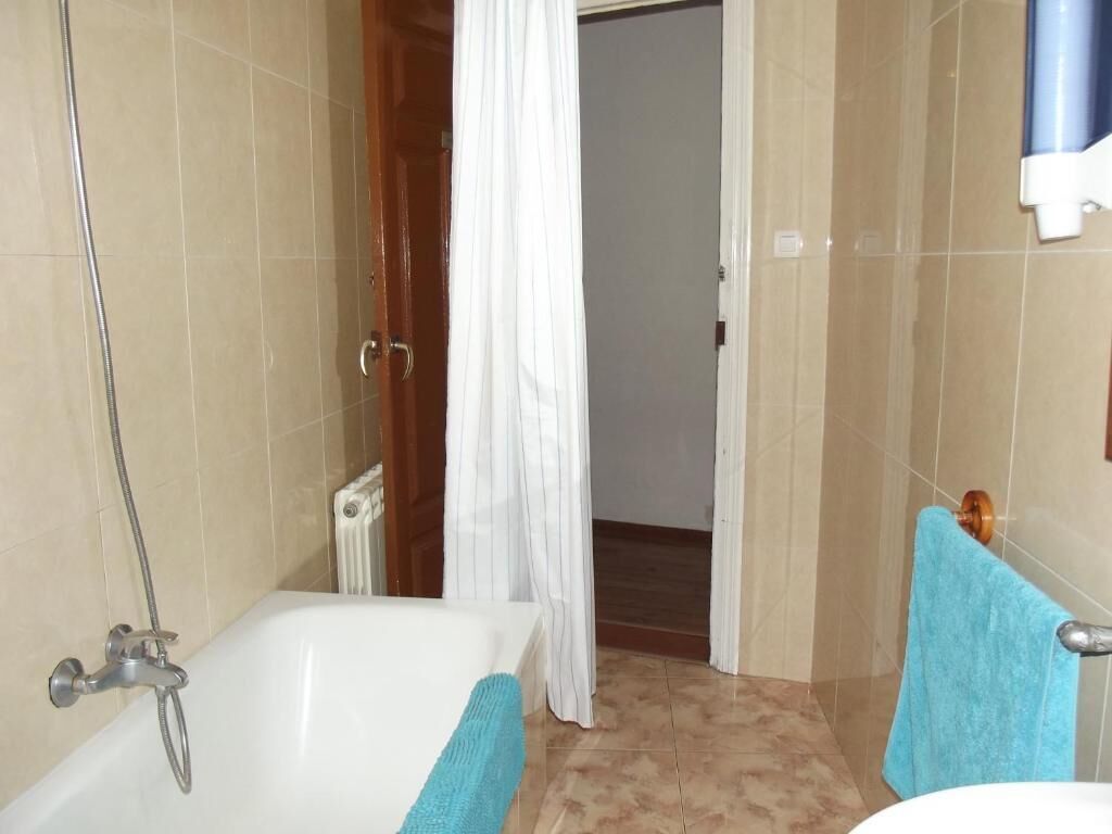 Un baño con bañera, ducha y perchero para toallas.