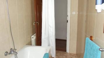 Un baño con bañera, ducha y perchero para toallas.