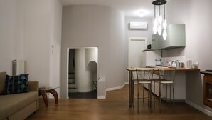 Un soggiorno moderno con divano, tavolino da caffè e zona pranzo con tavolo e sedie.