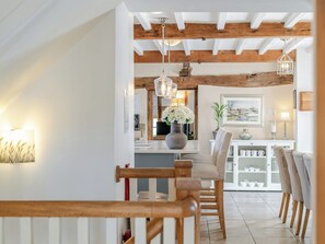 A modern kitchen with white cabinets, a wooden dining table, and hanging pendant lights. - 7 bedroom accommodation in Bradbourne, near Ashbourne (Bradbourne, near Ashbourne)