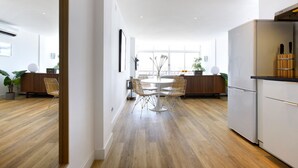 A modern kitchen with a dining area, wooden flooring, and a large window providing natural light. - Picasso Boutique (Torremolinos)