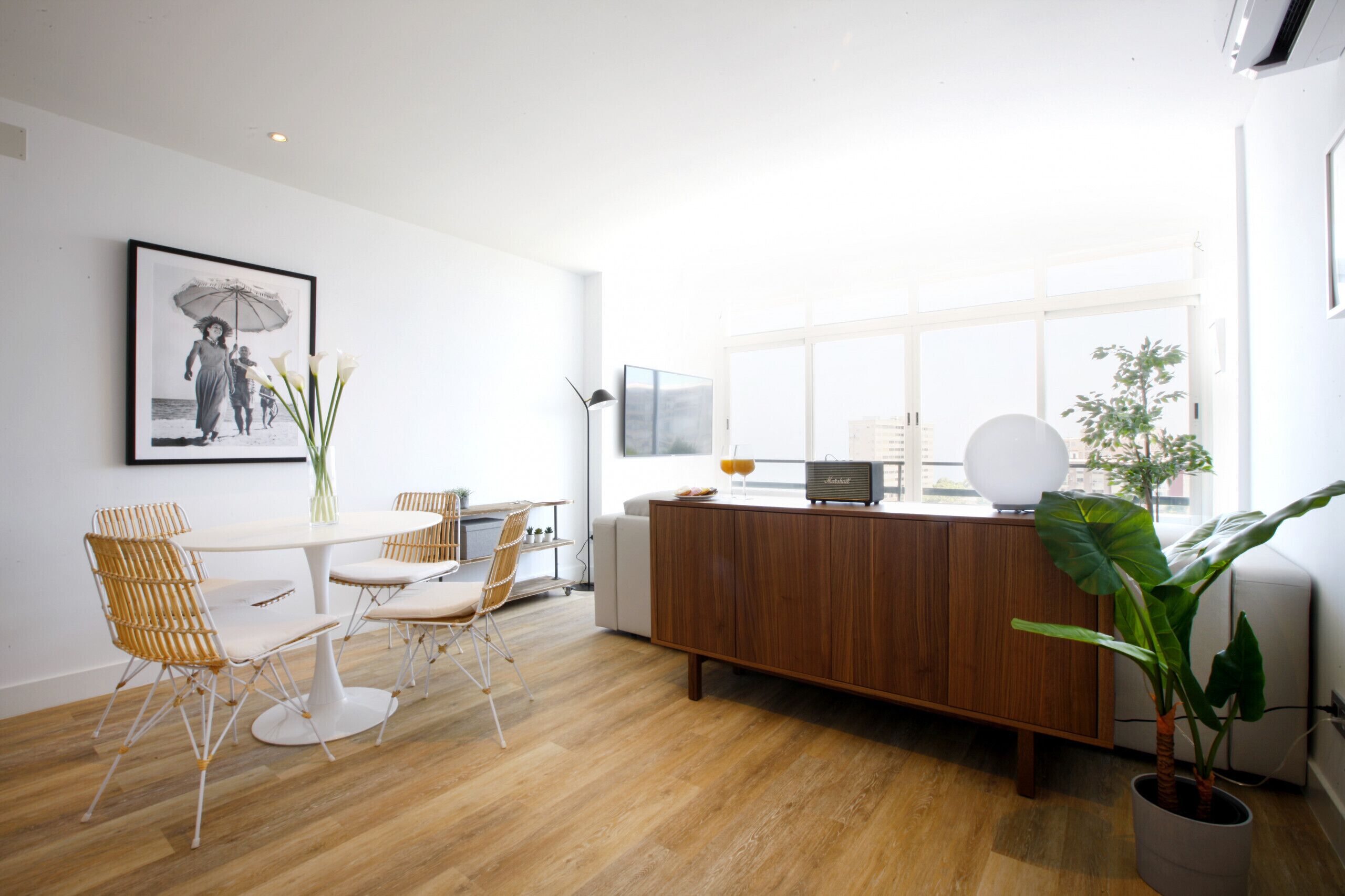 Een moderne keuken met een houten aanrechtblad, witte kastjes en een groot raam.