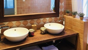 Casa de banho com duas pias, um espelho grande e zona de duche.