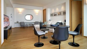A modern living room with a round dining table, four black chairs, a sofa, and a TV. - Charming  elegantly  apt in villa near the center but in a very quite area (taormina)