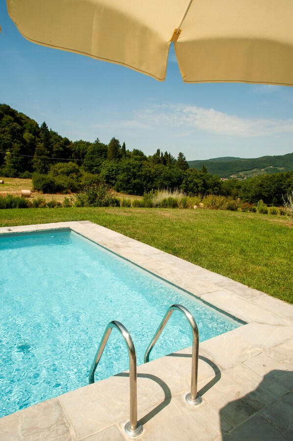 A swimming pool with a clear blue water, surrounded by a grassy area and trees. - Agriturismo Marchesi Gondi - Casavecchia (Pontassieve)