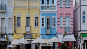 A row of colorful buildings with balconies, a street with umbrellas, and a sign for 'DARFOIS'. - 2 bedroom ground floor apartment, located on the award winning Lagos Marina   (Lagos)