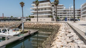 A coastal hotel with multiple balconies, a marina with boats, and palm trees. - 2 bedroom ground floor apartment, located on the award winning Lagos Marina   (Lagos)