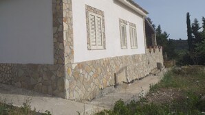 Un edificio de dos pisos con fachada de piedra y paredes blancas.