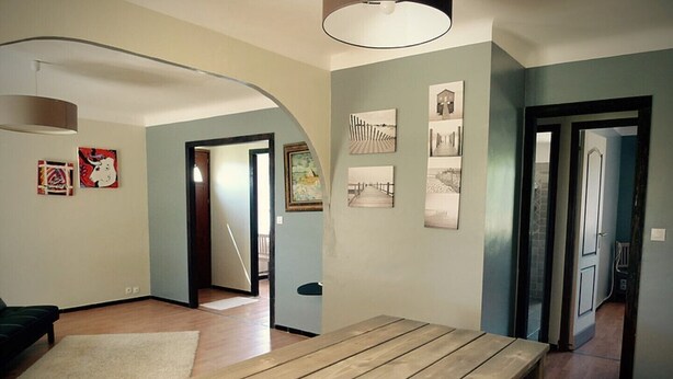 A spacious living area with a wooden bench, a sofa, and a large window. - Self catering Les Rizières + Cottage hunting (Saint-Gilles)