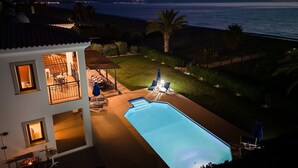 Una piscina con vista al océano al anochecer.