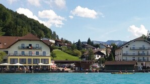 A waterfront hotel with multiple buildings, a dock, and a mountainous backdrop.