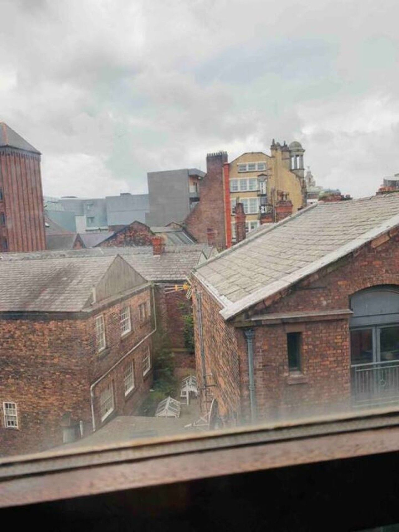 A residential area with brick buildings, a narrow alley, and a variety of architectural styles.