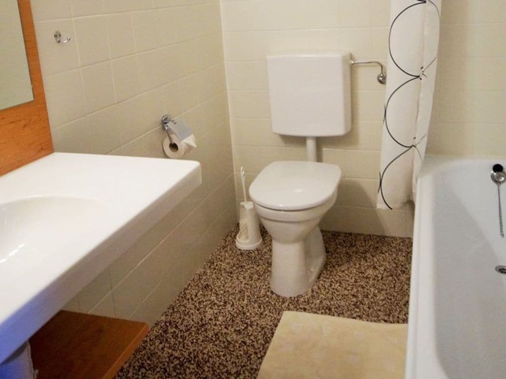 A bathroom with a white toilet, a white sink, and a bathtub.