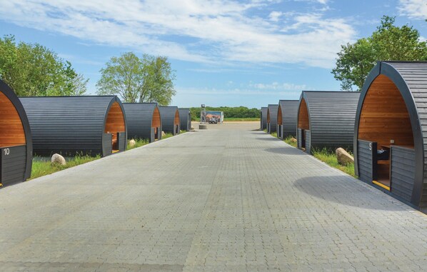 Une rangée de logements de type caravane, reliée par une allée pavée menant à un point central.