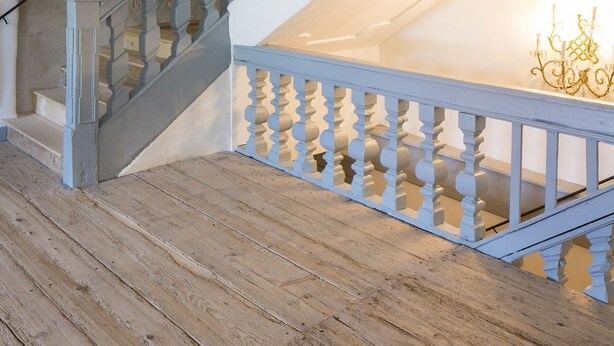 Een trap met een houten vloer en witte balustrades.