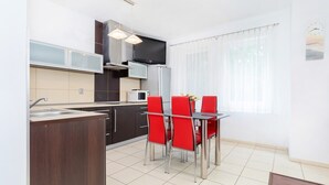 Una cocina moderna con comedor, que incluye una televisión, microondas y refrigerador.