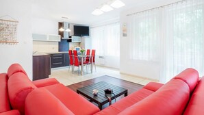Una sala moderna con sofás rojos, una mesa de centro y un comedor con sillas rojas.