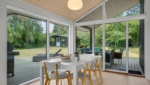 A modern dining area with a white table and chairs, large windows, and a view of the outdoors. - Nice home in Jægerspris with kitchen (Jægerspris)