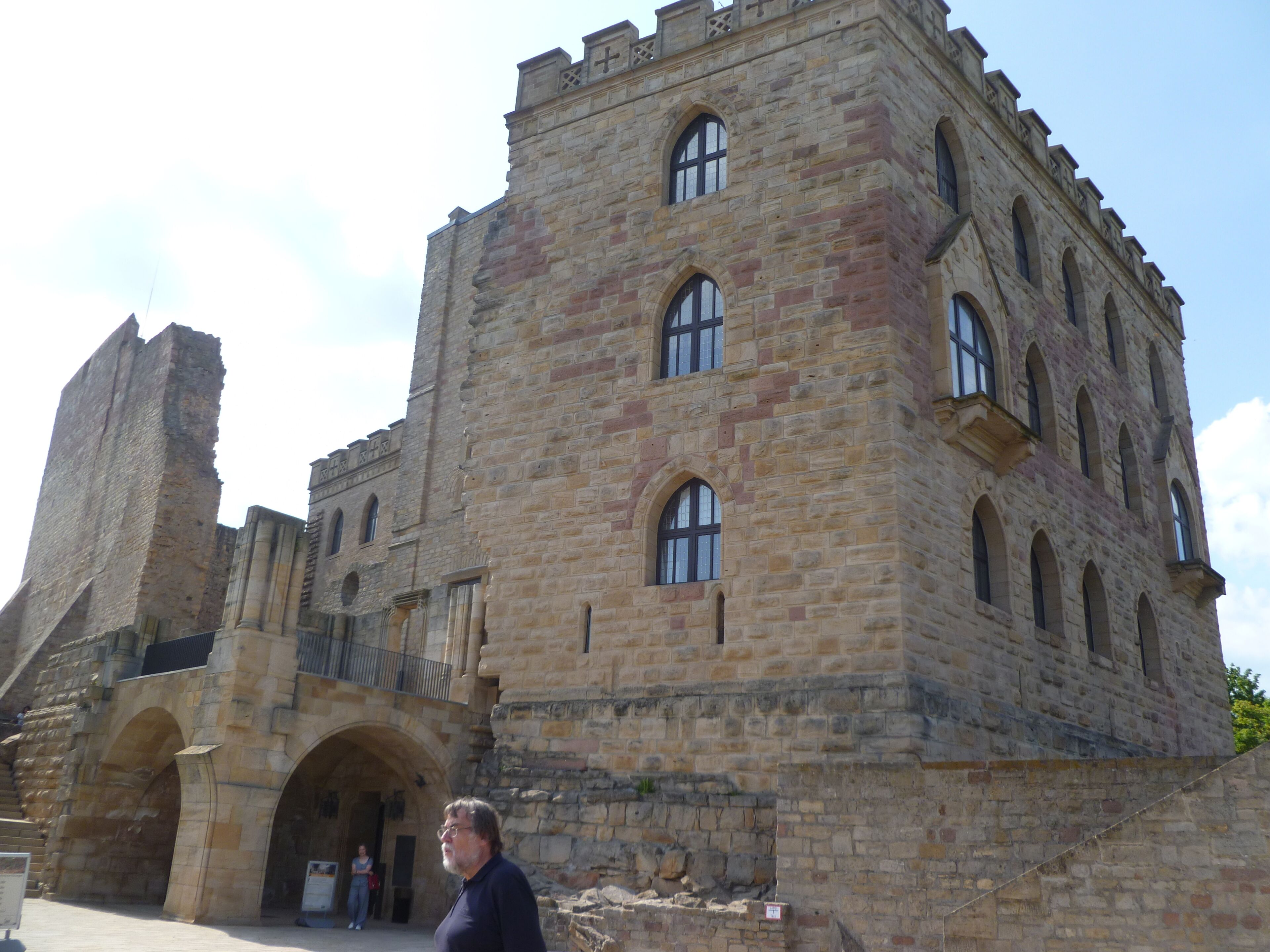 A historic stone building with arched windows and a prominent tower.