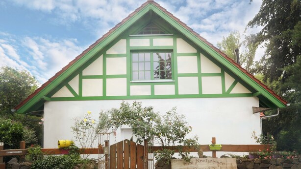A traditional half-timbered house with a stone wall and wooden gate. - Fewo star view in a very quiet location in Beelitz (Beelitz)