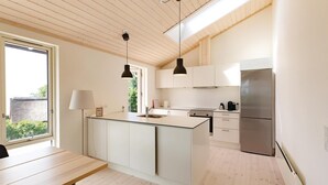 A modern kitchen with a central island, stainless steel appliances, and a large window providing natural light. - 3 bedroom nice home in Kalundborg (Kalundborg)