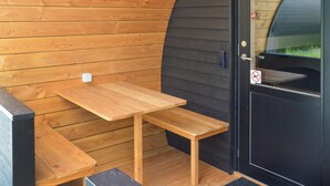 A small wooden bench and table set against a wooden wall with a black door. - 2 bedroom nice apartment in Nørre Nebel (Nørre Nebel)