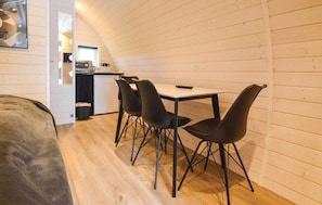 Cozy retreat with a compact kitchenette, dining area, and a comfortable bed.